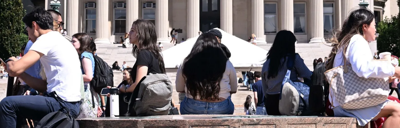 Students are seated around marble fountain of Low Plaza