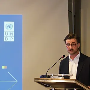 Alexander Hrdecky stands behind the podium at an UNDP event.