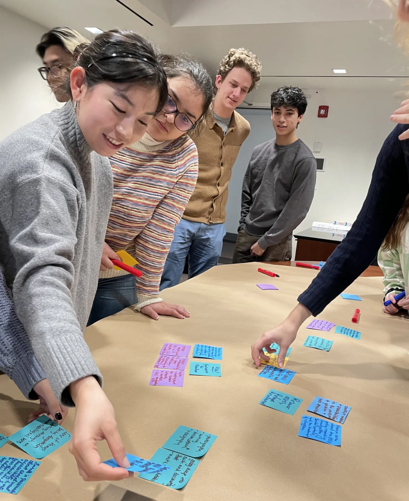 Global Thought undergraduate students brainstorming ideas with sticky notes.
